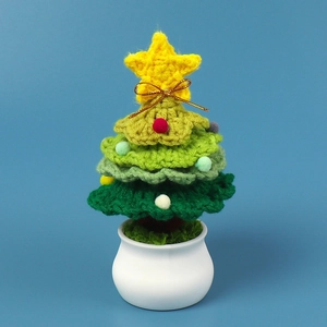 Handmade crochet Christmas tree in white ceramic pot with colorful pompoms for desk decoration