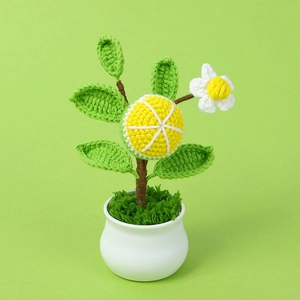 Macro view of handmade crochet lemon potted plant with vibrant yellow fruit and green leaves