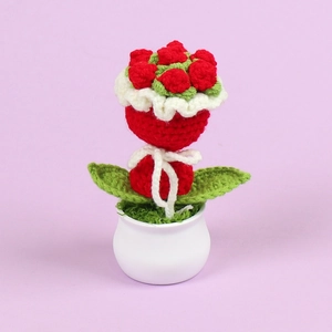 Detailed macro view of handmade crochet red rose bouquet in a white ceramic pot