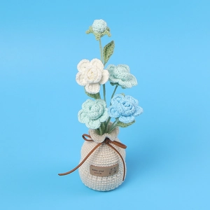Handmade crochet rose bonsai with blue and white flowers in a knitted pot for home decor