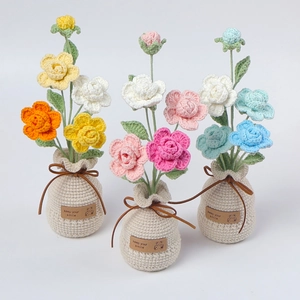 Detail of handmade crochet flower potted plants with bear label and vibrant petals