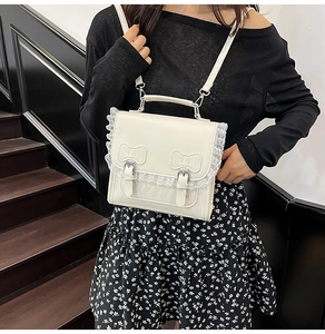 Détail du sac en similicuir blanc crème avec bordure en dentelle et double nœud