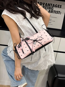 Elegante borsa sottobraccio rosa in jacquard con motivi a fiocco nero e ciondoli