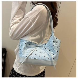 Dettaglio borsa a spalla in jacquard azzurro con fiocco e tessuto testurizzato