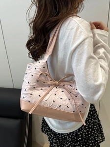 Bolso de hombro plisado rosa con estampados de lazos y un lazo decorativo grande