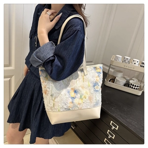 Floral embroidered tote bag with cream leather base shown on model in casual style