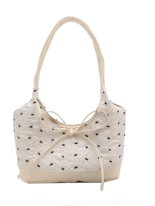 Bolso de hombro blanco con estampados de lazos negros y detalle de lazo grande