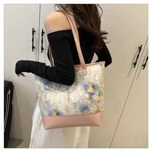 Dettaglio della grande borsa tote in pizzo floreale con tracolla rosa indossata