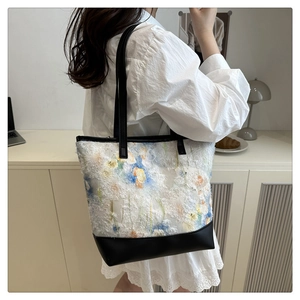 Dettaglio della borsa tote jacquard artistica con tracolla in pelle nera di qualità