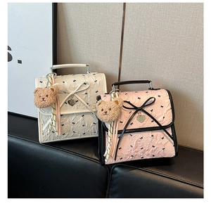 Dettaglio della borsa in seersucker con fiocchi, pois e ciondolo a forma di orso