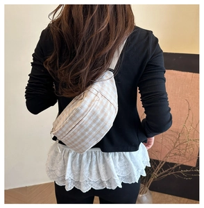 Detail of checkered canvas saddle bag showing thick texture and adjustable strap on back
