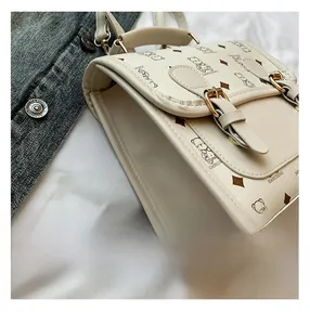 Detail showing beige faux leather backpack texture with bear pattern and gold buckles