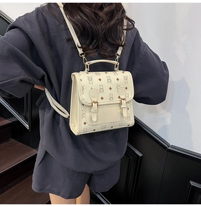 Detail of beige cartoon bear pattern backpack worn over a dark grey sweater