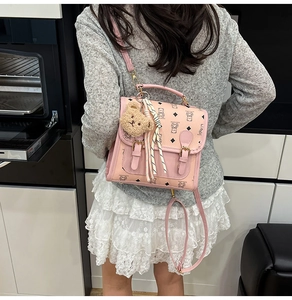 Detail of pink cartoon bear backpack with plush charm and polka dot ribbon decoration