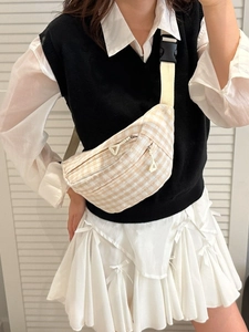 Checkered beige and white crossbody fanny pack with dual zippers and adjustable strap