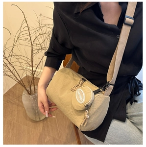 Detailansicht der khakifarbenen Nylon-Umhängetasche mit verstellbarem Gurt und kleiner Geldbörse