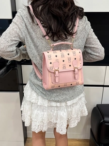 Pink cartoon bear printed backpack with vintage flap and adjustable straps worn by model