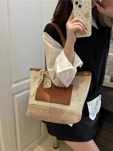 Large capacity woven straw tote bag with brown leather handles and a white lace bow detail
