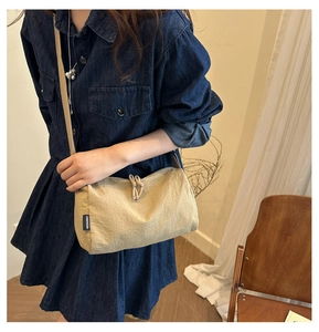 Détail du sac à bandoulière en nylon kaki avec nœud et étiquette de marque