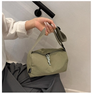 Détail du sac en nylon vert sauge montrant l'étiquette FANYISSA et le cordon tressé
