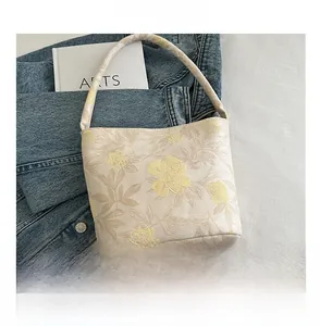 Detailansicht der Jacquard-Beuteltasche mit Blumenmuster und Größenvergleich zum Smartphone