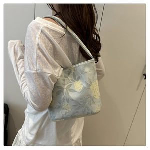 Seitenansicht einer floral bestickten Canvas-Beuteltasche getragen von einem Model