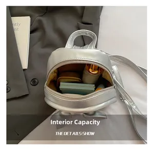 Interior view of small silver metallic backpack showing storage for lipstick and cosmetics