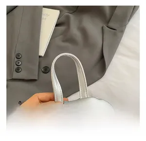 Macro detail of silver mini backpack showing smooth metal zipper and top handle