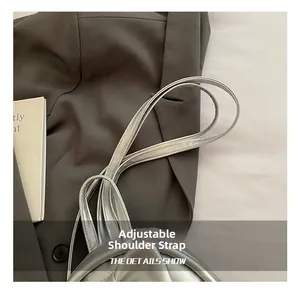 Silver leather handbag with a focus on its adjustable and stylish shoulder strap detail