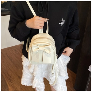 Detail eines weißen Mini-Rucksacks mit großer Schleife und glatter Lederstruktur