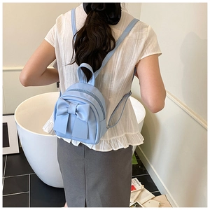 Rückansicht eines hellblauen Mini-Rucksacks mit großer Schleife an einem Model