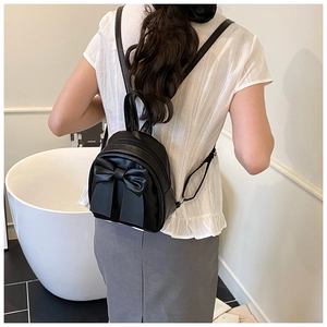 Detail of black mini backpack with large bow design and adjustable PU leather straps