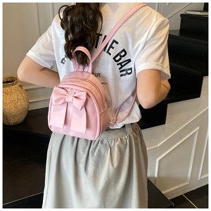 Detailansicht eines süßen rosa Mini-Rucksacks mit großer Schleife und glatter Lederoptik