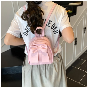 Close-up of a pink mini backpack featuring a stylish 3D bow and premium PU leather finish