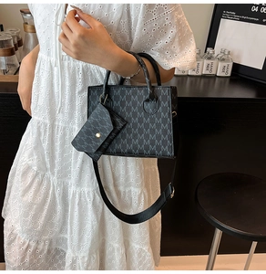 Dettaglio della borsa shopper grigia con motivo monogramma e piccolo borsellino rotondo