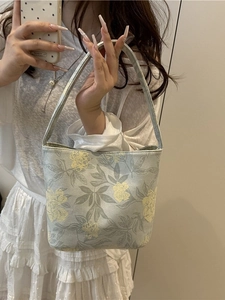 Florale Canvas-Beuteltasche für Damen mit blau-gelbem Blumenmuster in der Hand