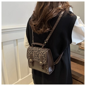 Modell trägt Retro-Rucksack mit Leopardenmuster, braunem Leder und Metallschnalle