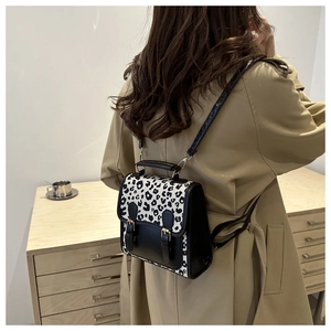 Detail of leopard print backpack showing the chic buckle straps and stylish leather finish