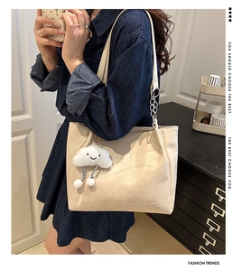 Detail of off-white tote bag with geometric stitching and cute cloud plush charm