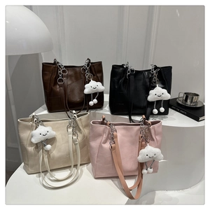 Chic tote bags in four colors with chain detail and plush cloud charms on a modern display