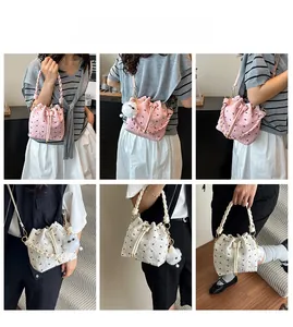 Detailansicht einer rosa Eimertasche mit Schleifenmuster und flauschigem Anhänger