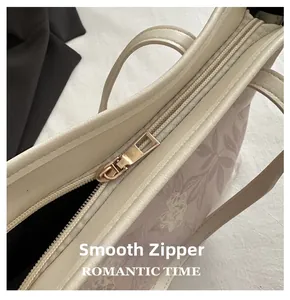 Detail of smooth gold zipper and floral print on elegant beige tote handbag