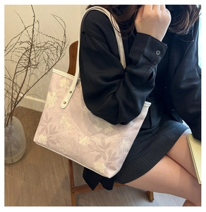 Close-up of lilac tote bag with white floral patterns and elegant leather straps