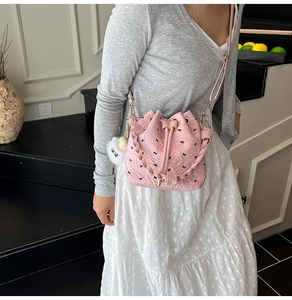 Detailansicht einer rosa Beuteltasche mit schwarzen Schleifen, gewebtem Griff und Plüsch