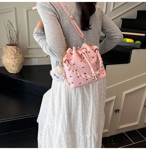Rosa Kordelzug-Beuteltasche mit schwarzen Bogenmustern und Plüschbär-Anhänger