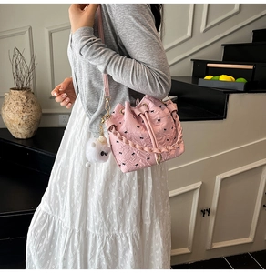 Rosa Eimertasche mit schwarzer Schleifenstickerei und flauschigem Anhänger im Detail