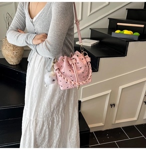 Detail der rosa Beuteltasche mit Schleifenprägung, Kordelzug und Pompon-Anhänger