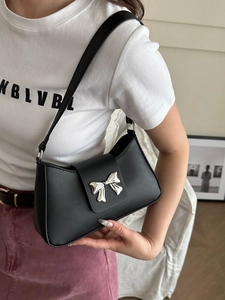 Sac baguette noir en cuir PU avec boucle nœud argentée porté par un mannequin