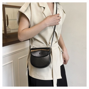 Detailed view of a vintage black saddle bag with smooth leather texture and metal clasp
