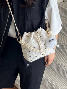 Weiße Beuteltasche mit schwarzen Schleifen-Prints, Plüsch-Anhänger und Schultergurt